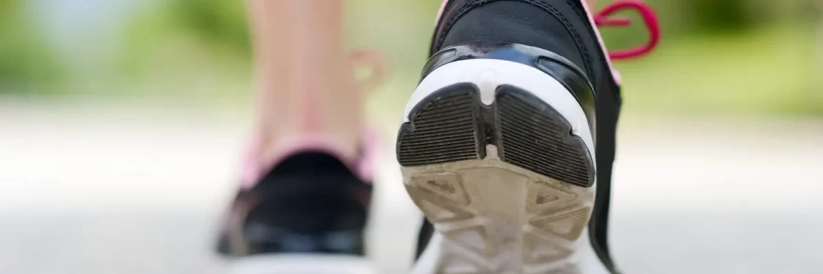 Woman feet running on road closeup on shoe