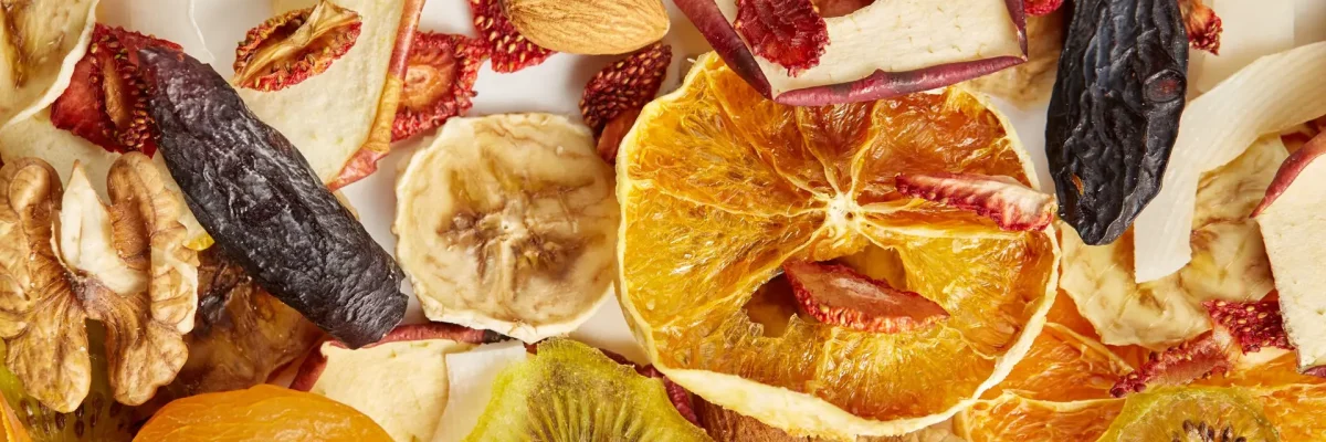 Different dried fruits and nuts. Close up of almonds, dried apricot, raisins, walnuts, dried apples, orange, bananas and kiwi on white background. Concept of organic healthy assorted dried fruit for snacks.